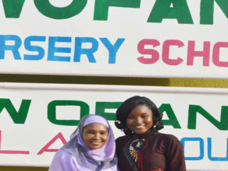 Zdjęcie przedstawia Salamatu Garbę w jasno-fioletowej chuście zakrywającej głowę i ramiona oraz Agathę Diamę z International Crops Research Institute for the Semi-Arid Tropics. Stoją obok siebie i się uśmiechają do zdjęcia.