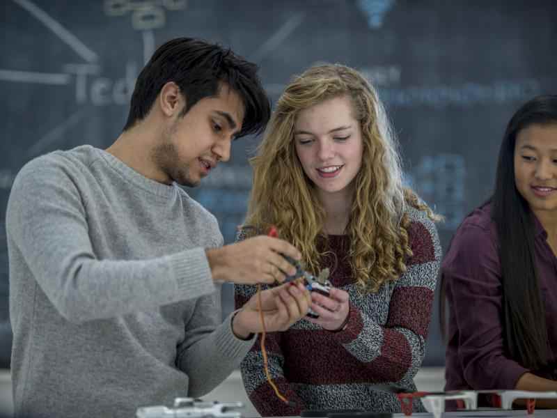 Two teens work together on a robotics project in science class
