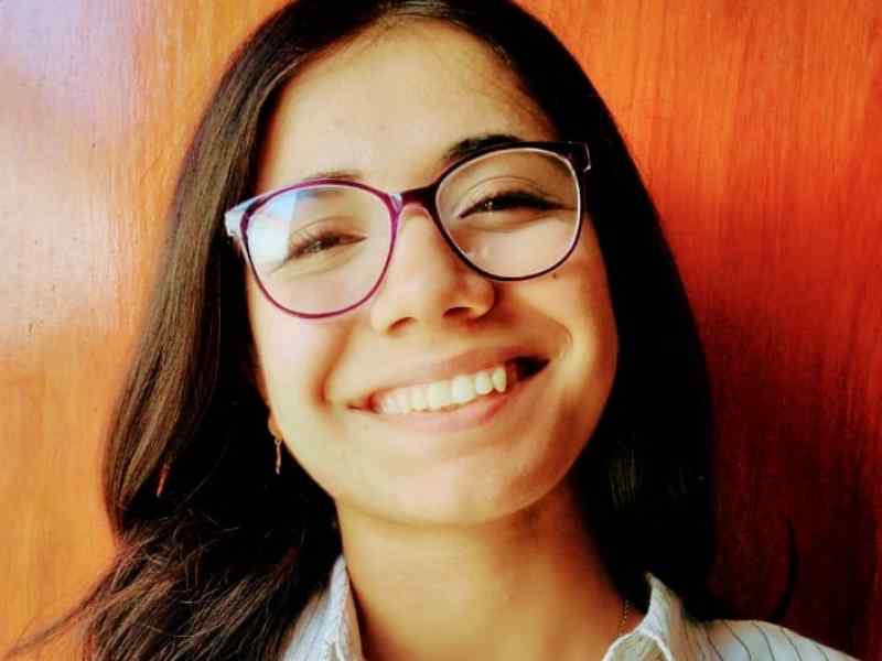 Sandra Gómez con un fondo de madera