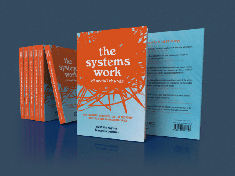 Graphic for the cover of the book "The Systems Work of Social Change" by Cynthia Rayner and Dr. François Bonnici. Dark blue background. 5 books with an orange spine stacked horizontally against each other. In the center, Cover of The Systems Work of Social Change – Half the cover is orange with scribbles, the other half a gradient going from light blue to white at the bottom. Words at top in white: The Systems Work (in big bold letters, all undercase) of Social Change (in smaller letters, all lower case).