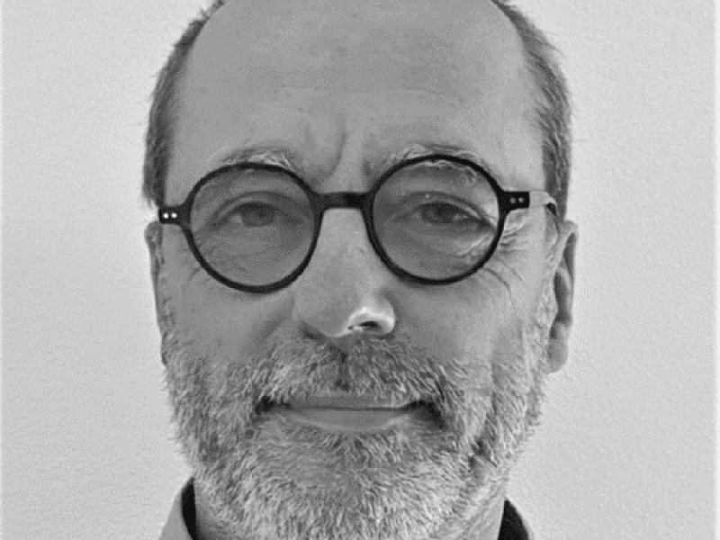 photo de Pierre De Rauglaude - cheveux coupés ras, barge grise et lunettes rondes et noires