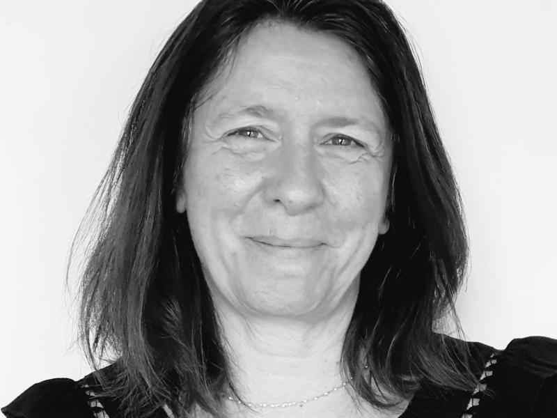 photo en noir et blanc d'une femme cheveux longs souriante