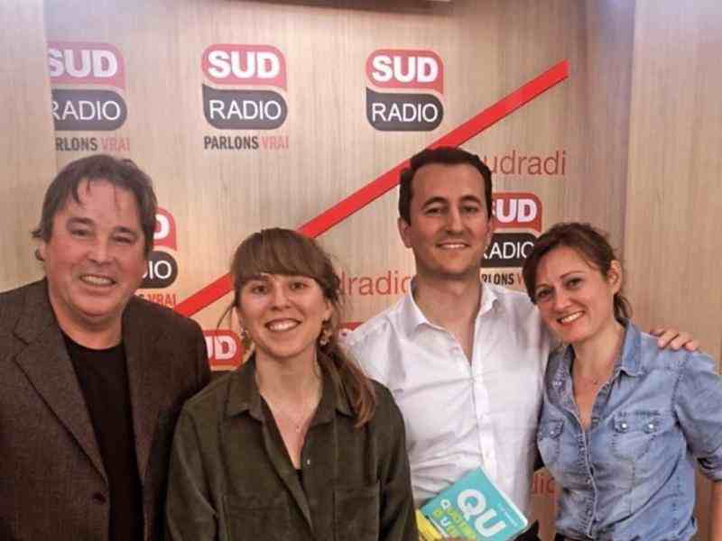 groupe de personnes souriants à l'objectif derrière dans le studio de la radio Sud Radio