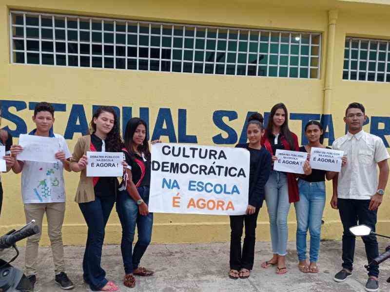 Grupo de jovens seguram cartazes sobre cultura democrática