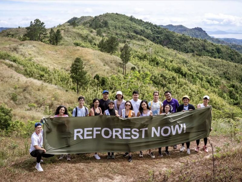 Group shot of Masungi Staff. They are holding a banner that says "Reforest Now". 