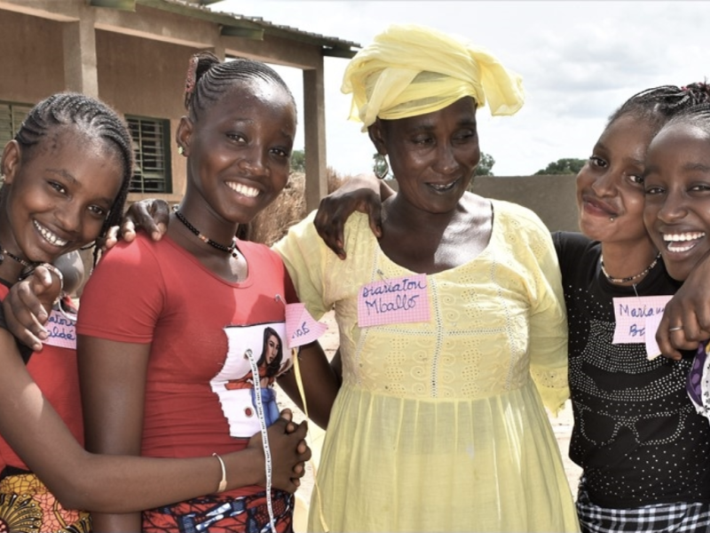 Senegalese grandmother with group of young girls in her community