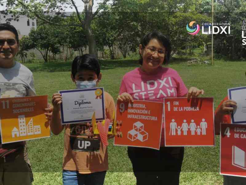 Un hombre, un niño, una mujer y otro niño aparecen en la imagen con carteles en la mano que muestran los Objetivos de Desarrollo Sostenible