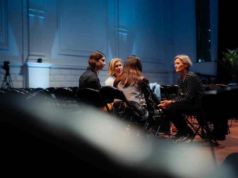 Photo of small seated group in conversation in the conference hall