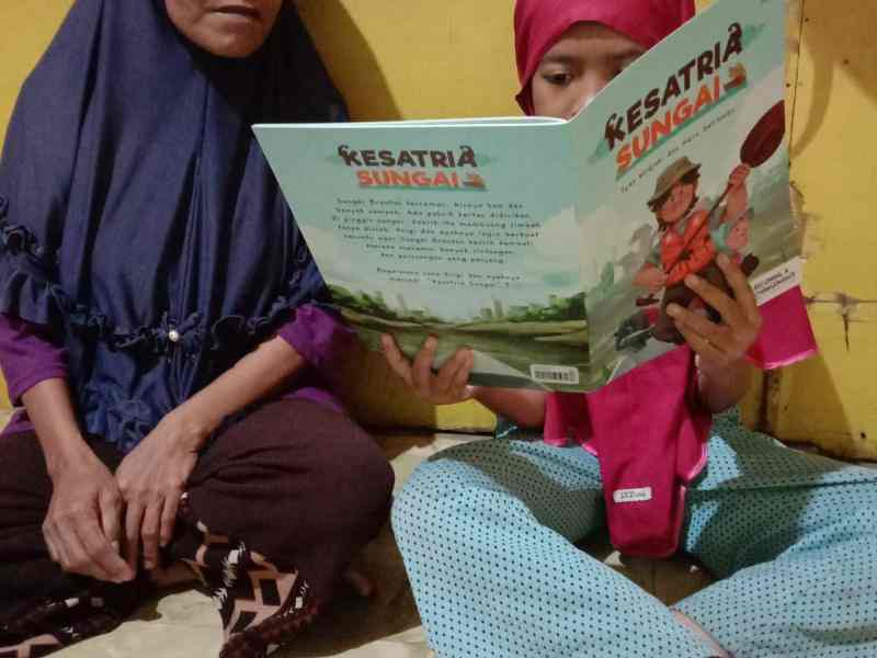 A little girl read changemaking book with her grandmother 