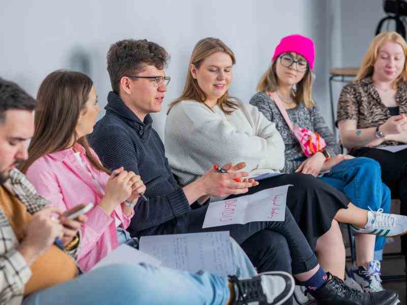 6 young people sitting in a room
