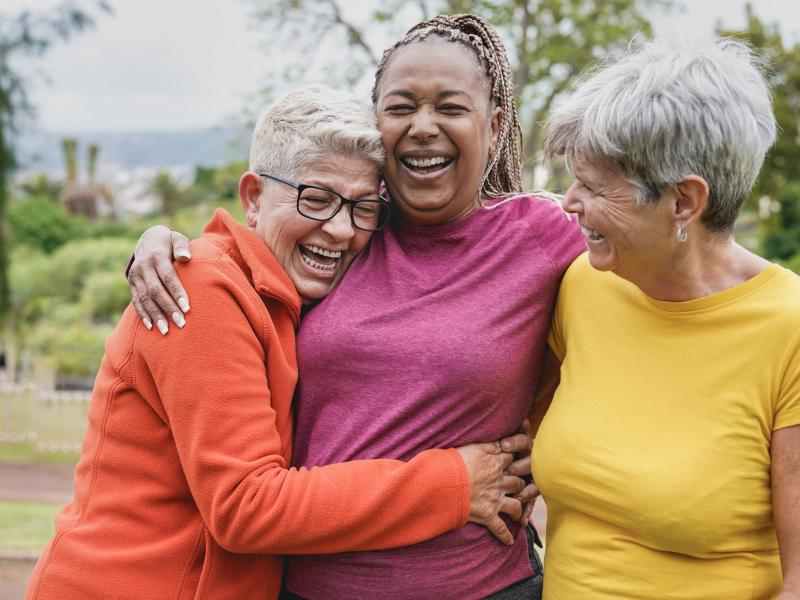 três mulheres de meia idade abraçadas