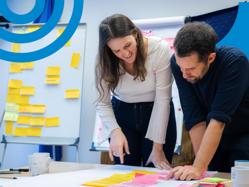 Young woman and man looking at post-its on the desk