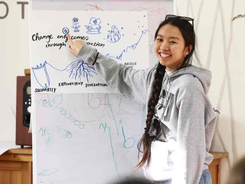 Young woman presenting something on the board, smiling