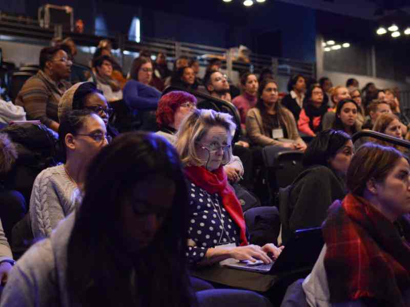 Photo of an audience seated in an indoor auditorium