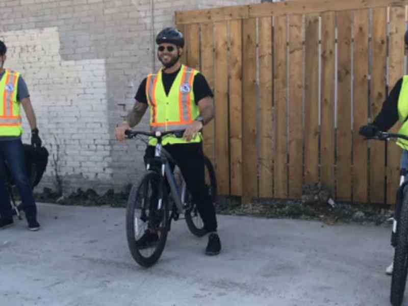 Three people part of the Bear Claw Patrol sitting on bikes