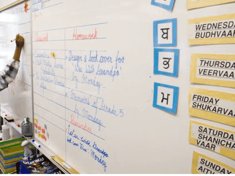 Student writing on a white board with an expo marker