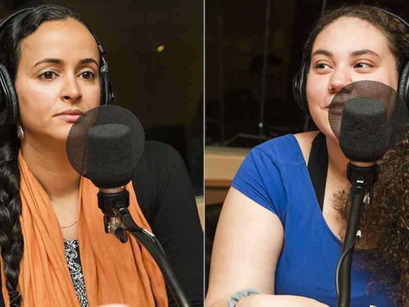 Two young women speaking into microphones with headphones on