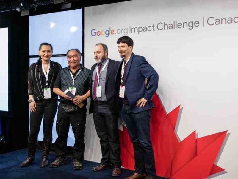 Photo of four members of SIKU team in front of Google Imapact Challenge banner