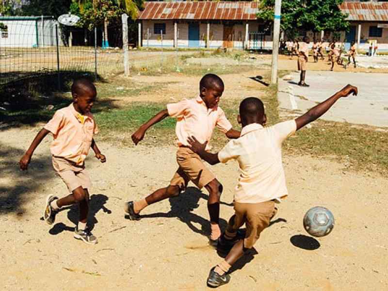 Children playing soccer in a playground