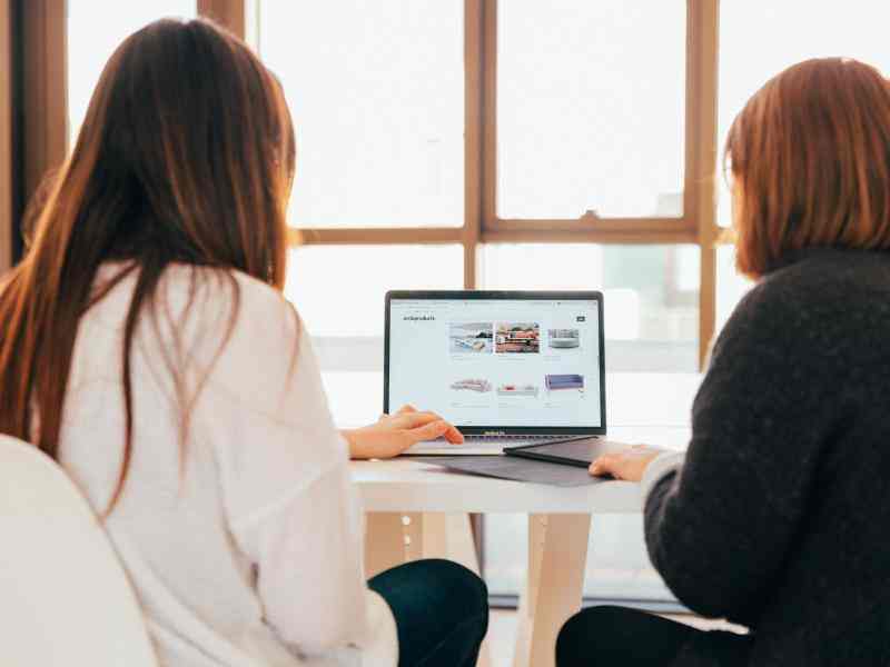 Two people looking at a computer in an office