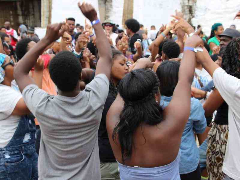 Photo of a group of youth jumping with arms up in a courtyard
