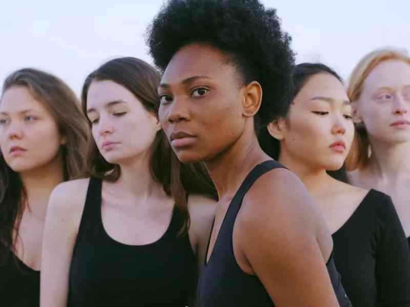 Five women in a line looking off camera
