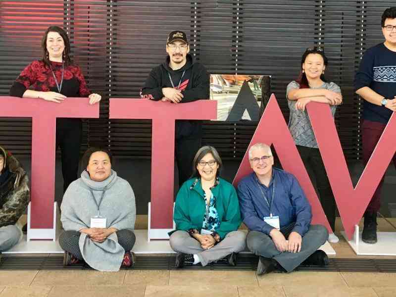 Group of youth posing with a giant OTTAWA sign in outlined 3D lettering