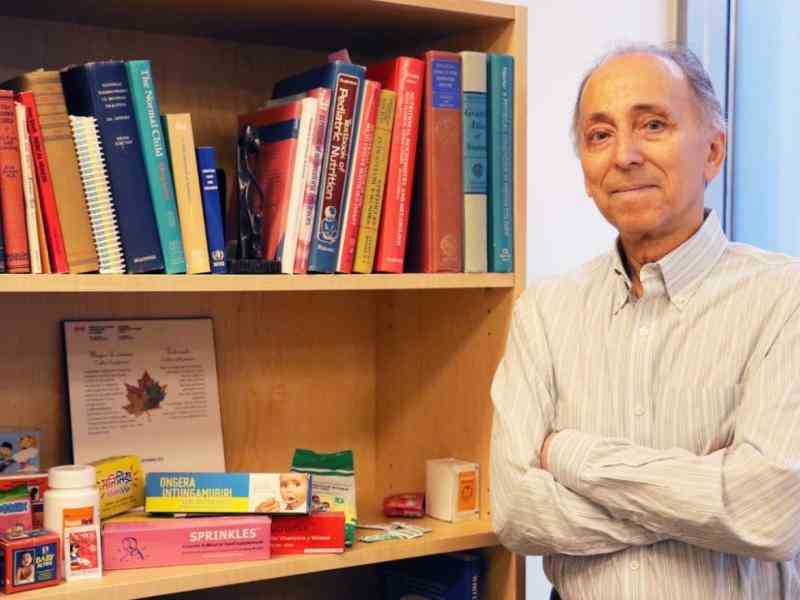 Photo of Canada Fellow Stanley Zlotkin next to a bookcase showcasing his nutrition and hunger fighting product Sprinkles