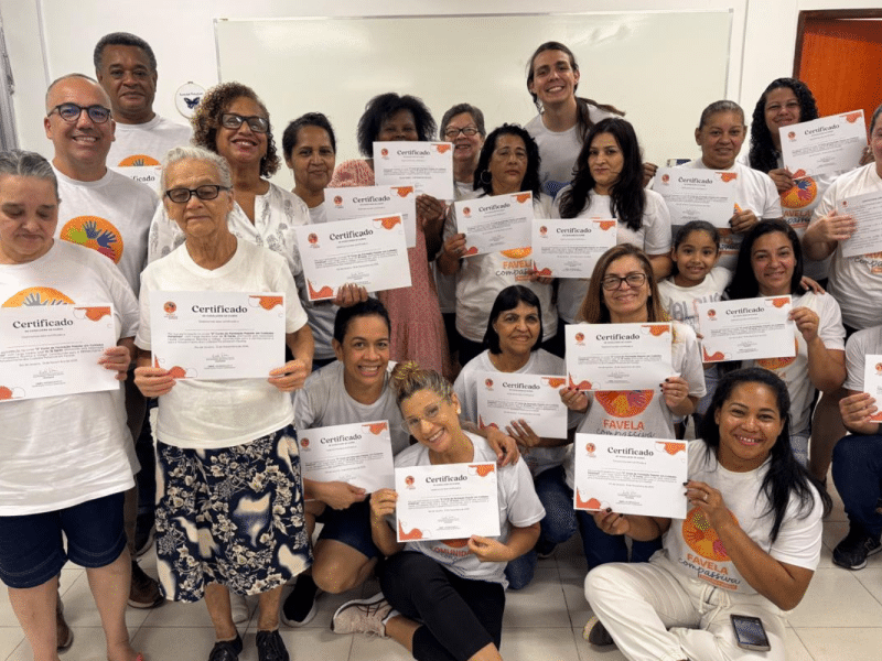 Grupo de pessoas reunidas em uma sala segurando certificados
