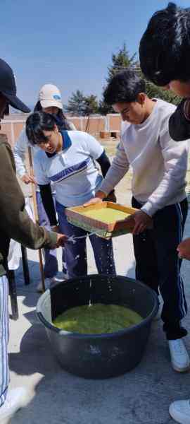 Fotografía de un grupo de estudiantes colando la mezcla para realizar papel.