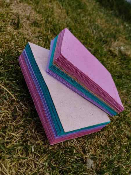 Fotografía de hojas de papel recicladas de colores.