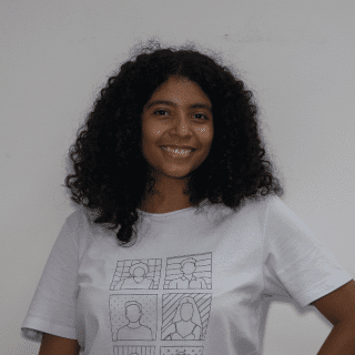 Livia is a black girl with dark curly hair. She is wearing a white T-shirt