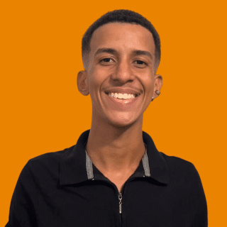 Igor é um jovem negro de cabelos curtos. Ele sorri para a foto