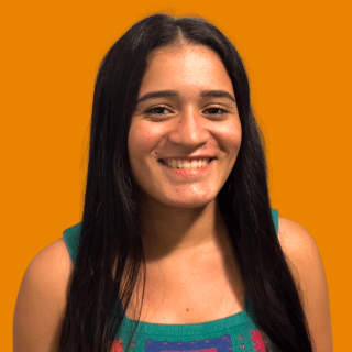 Thalya é uma jovem com cabelos longos e lisos. Ela sorri para a foto
