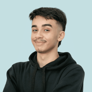 Lucas é um jovem branco com bigode, cabelo castanho, curto e raspado nos lados. Ele usa um moletom preto com capuz
