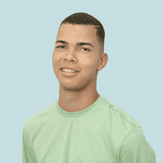 Matheus é um jovem pardo com cabelo castanho e raspado. Ele veste uma camiseta verde e sorri para a foto