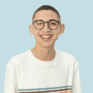 José e um jovem branco de cabelo castanho raspado. Ele usa óculos, uma camiseta branca com listras horizontais no centro e sorri para a foto